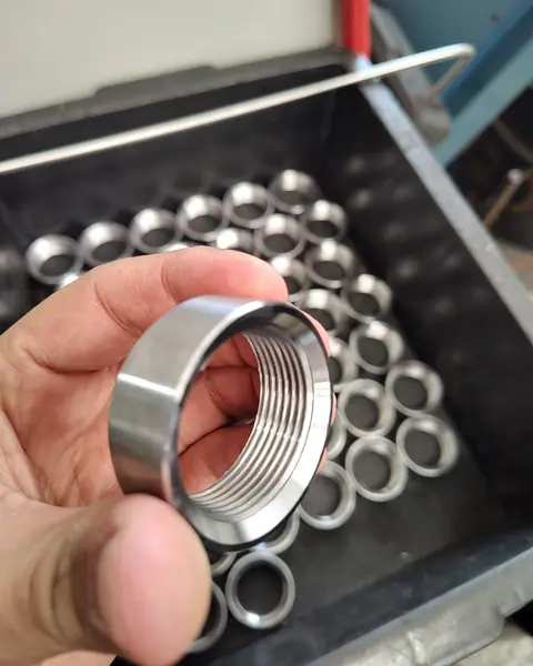 Anel de metal com rosca por dentro, na mão